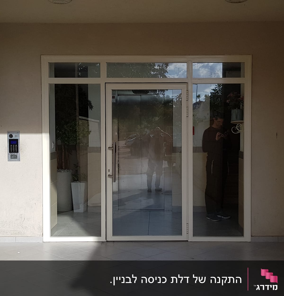 דלת זכוכית עם מסגרת אלומיניום בכניסה לבניין